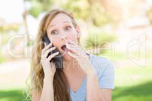 Stunned Young Woman Outdoors Talking on Her Smart Phone.