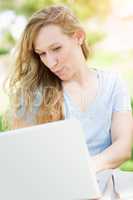Young Adult Woman Live Video Chatting Outdoors Using Her Laptop.