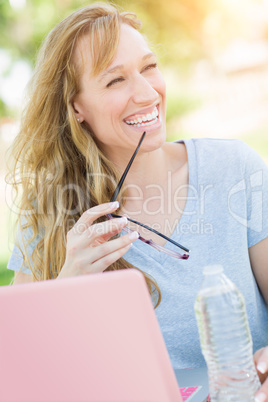Young Adult Woman With Glasses Outdoors Using Her Laptop.