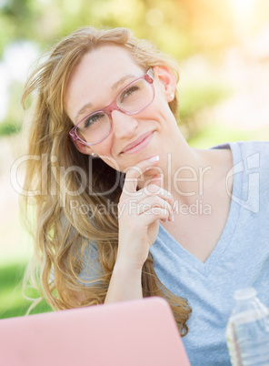 Young Adult Woman Wearing Glasses Outdoors Using Her Laptop.