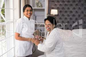 Smiling nurse and female patient at home