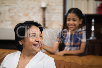 Smiling mature woman sitting on sofa