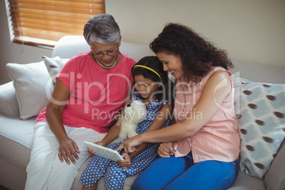 Happy family using digital tablet in living room