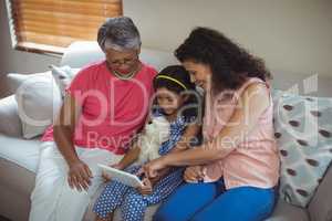 Happy family using digital tablet in living room