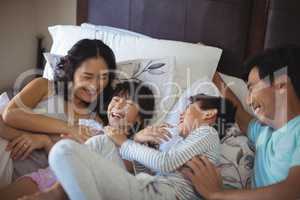 Happy family having fun on bed in the bed room