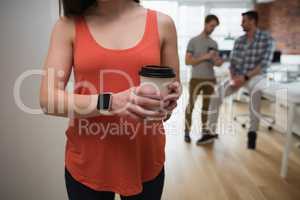 Female executive holding coffee cup in office
