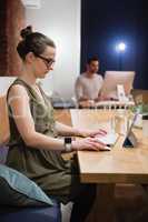 Female executive using digital tablet at desk