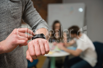 Male executive adjusting a smart watch in office