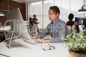 Male executive working on computer in office