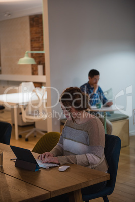 Female executive using digital tablet at desk