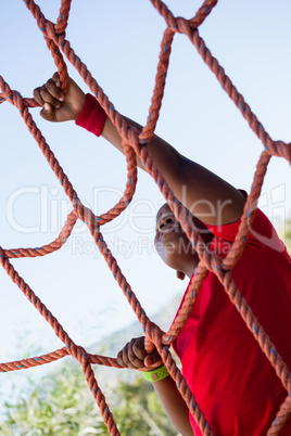 Boy climbing a net during obstacle course training