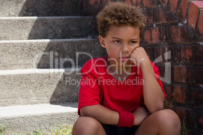 Upset boy sitting on staircase in the boot camp