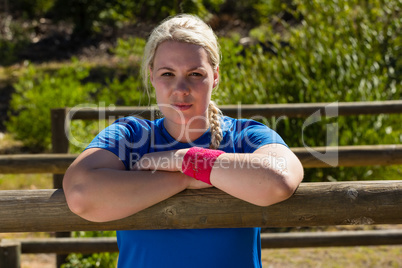 Fit woman leaning on hurdles during obstacle course training in the boot camp