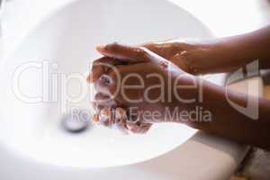 Cropped image of person washing hands at sink