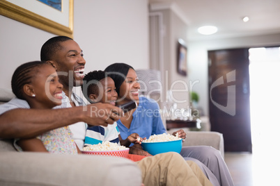 Cheerful family having popcorn while watching television