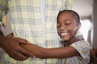 Mid section of man embracing smiling daughter