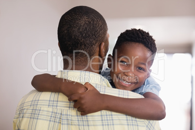 Happy boy embracing father at home