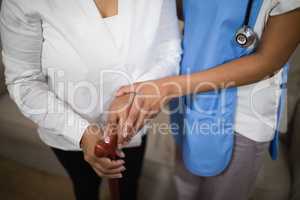 Mid section of nurse standing with patient