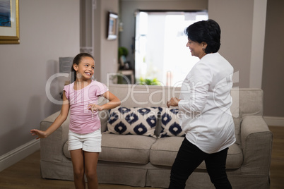 Smiling girl dancing with grandmother