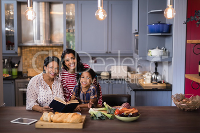 Portrait of smiling multi-generation family sitting in kitchen