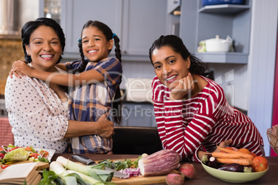 Portrait of happy multi-generation family standing in kitchen