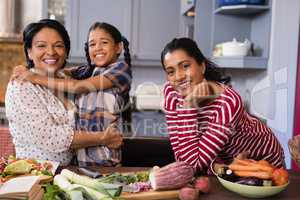 Portrait of happy multi-generation family standing in kitchen