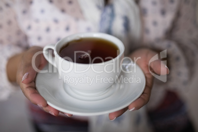 Mid section of woman holding tea cup