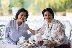 Portrait of woman having breakfast with mother