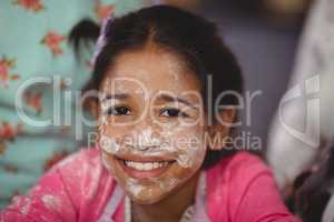Portrait of smiling girl with flour on face