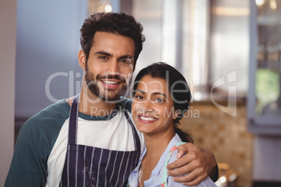 Portrait of smiling couple embracing in kitchen