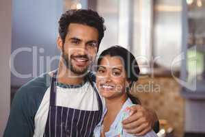 Portrait of smiling couple embracing in kitchen