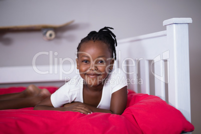 Portrait of smiling girl lying on bed