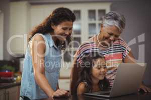 Happy family using laptop in kitchen