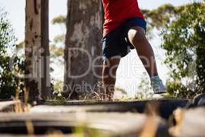 Boy running over tyres during obstacle course training