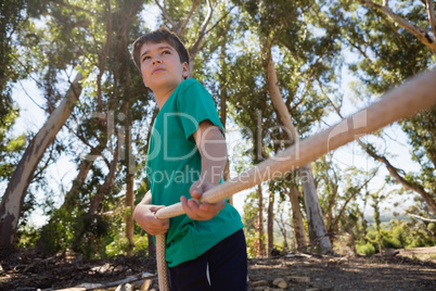 Boy practicing tug of war during obstacle course training