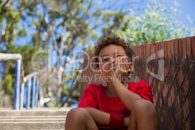 Upset boy sitting on staircase in the boot camp