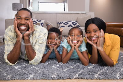 Portrait of smiling family lying on rug