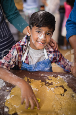 Portrait of smiling boy preparing food in kitchen
