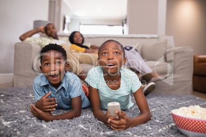 Children watching television while parents sitting at home