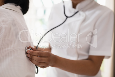 Mid section of nurse examining patient