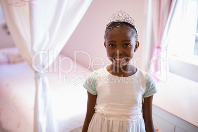 Smiling girl wearing fairy costume in bedroom at home