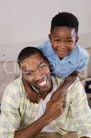 Cheerful father and son in living room at home