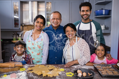 Portrait of smiling multi-generation family standing together in kitchen