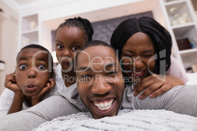 Portrait of happy family lying on bed