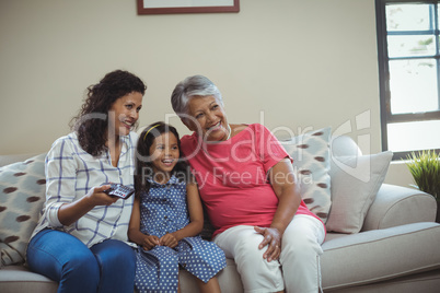 Smiling family watching television together in living room