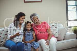 Smiling family watching television together in living room