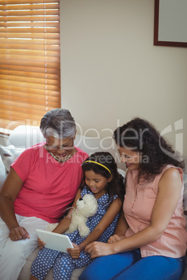 Happy family using digital tablet in living room