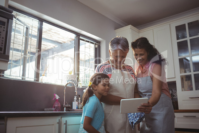 Happy family using digital tablet in kitchen