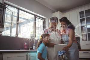 Happy family using digital tablet in kitchen