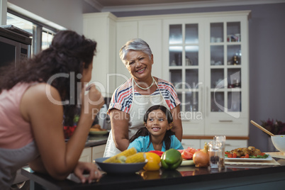 Smiling family interacting with each other in kitchen